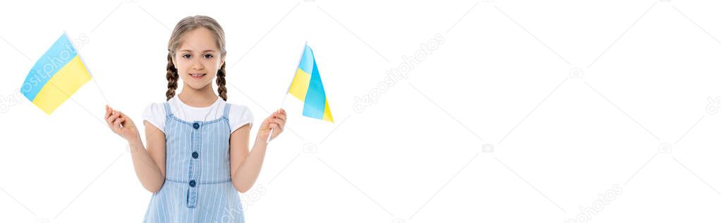 girl in blue strap dress holding small ukrainian flags isolated on white, banner