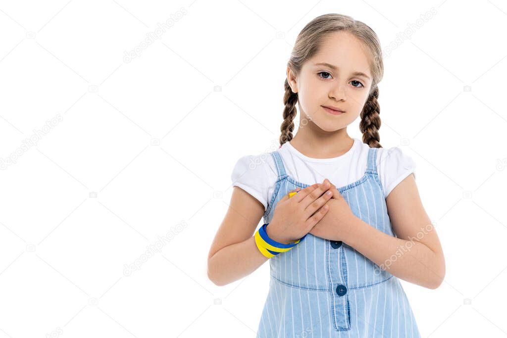 ukrainian girl with blue and yellow patriotic ribbon touching heart isolated on white