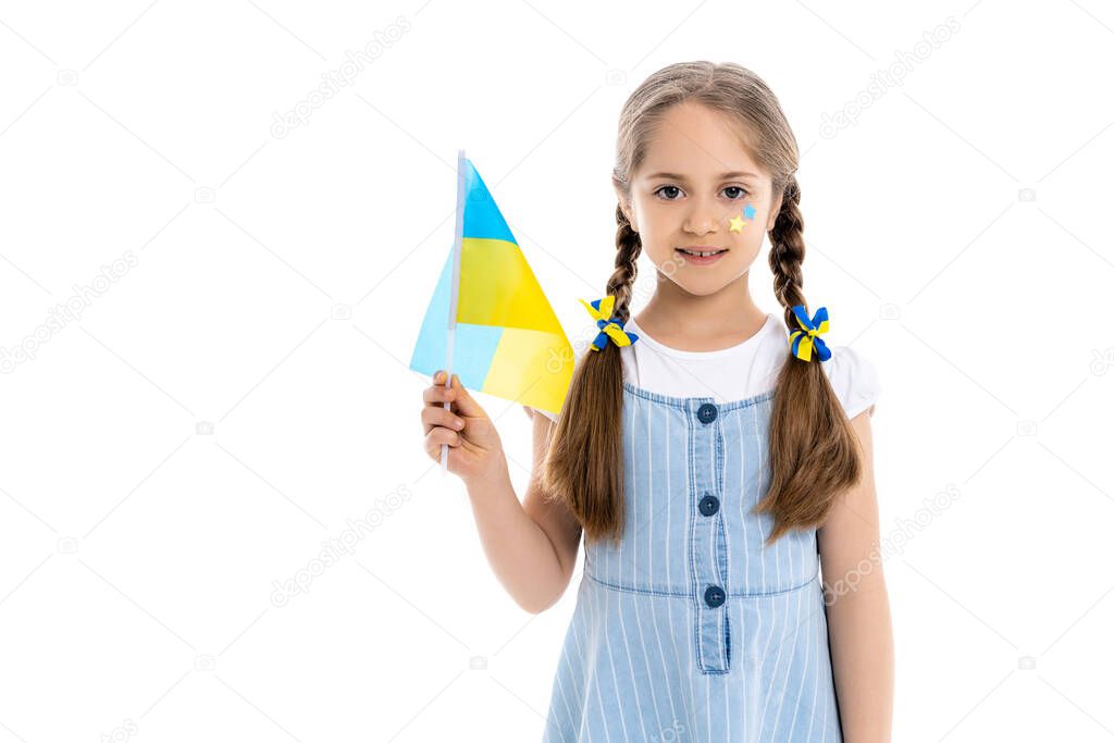 patriotic girl with blue and yellow stars and ribbons holding ukrainian flag isolated on white