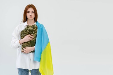 Ukrayna bayrağı taşıyan kızıl saçlı kadın askeri üniformayı beyaza sardı. 