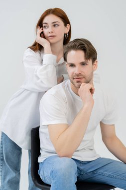 Genç adam, bulanık kız arkadaşının yanındaki sandalyede oturuyor. 