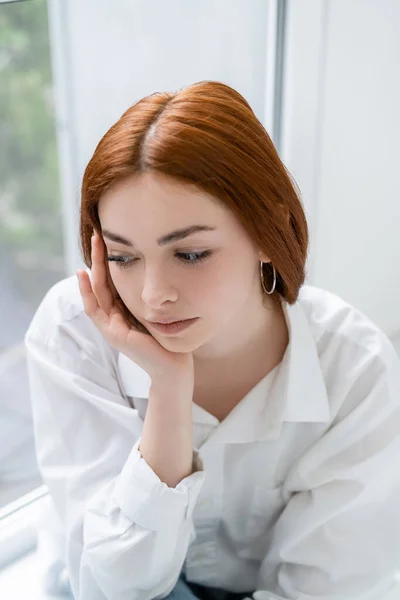 Ontevreden Roodharige Vrouw Zit Bij Het Raam Thuis — Stockfoto