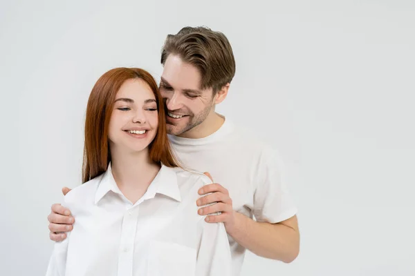 Positieve Man Knuffelen Jonge Vriendin Shirt Geïsoleerd Wit — Stockfoto