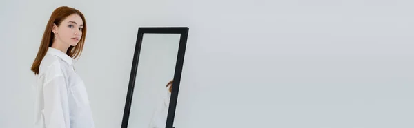 Mujer Pelirroja Bonita Mirando Cámara Cerca Del Espejo Aislado Blanco — Foto de Stock