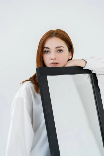 Pelirroja Mujer Camisa Mirando Cámara Cerca Del Espejo Aislado Blanco — Foto de Stock