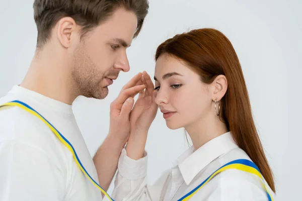 Jong Paar Met Blauw Geel Lint Houden Handen Geïsoleerd Wit — Stockfoto