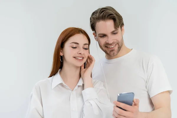 Casal Positivo Usando Fones Ouvido Smartphone Isolado Branco — Fotografia de Stock