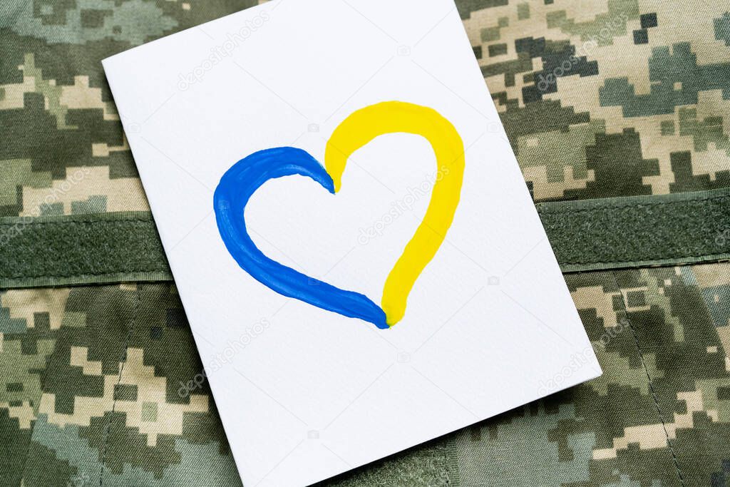 Top view of card with blue and yellow heart sign on military uniform 