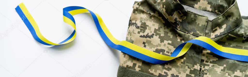 Top view of military uniform and blue and yellow ribbon on white background, banner 