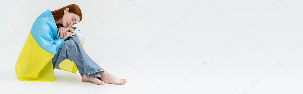 Young woman with closed eyes and ukrainian flag on white background, banner 