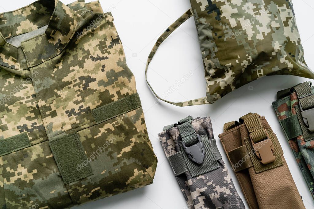Top view of military uniform and bags on white background 
