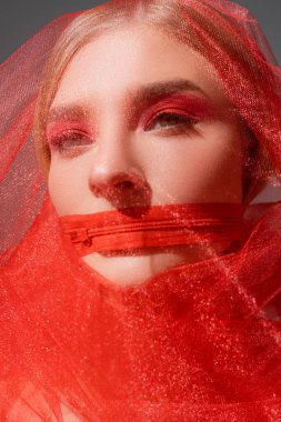 Young woman in tulle cloth and red zipper on mouth isolated on grey  clipart