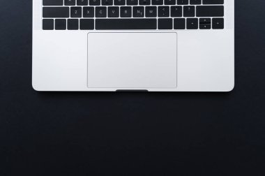 top view of laptop keyboard and touchpad on black
