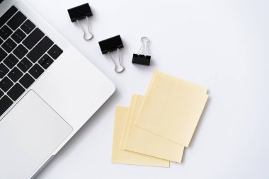 top view of laptop near stationery on white