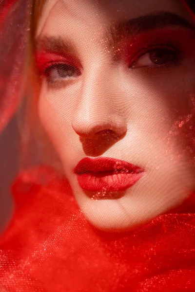 Młoda Kobieta Czerwonymi Ustami Oglądająca Kamerę Pobliżu Tiulu Szarym Tle — Zdjęcie stockowe