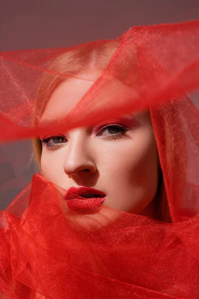 Jong Model Met Rode Lippen Kijkend Naar Camera Nabij Doek — Stockfoto