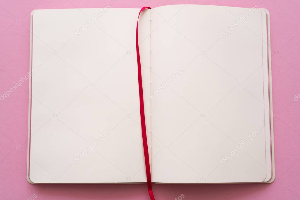 top view of open and empty notebook on pink 