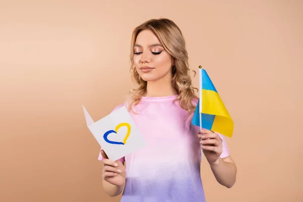 Woman Reading Card Blue Yellow Heart Holding Small Ukrainian Flag — Stock fotografie