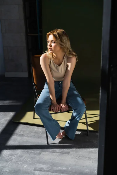 Full Length View Slim Woman Jeans Sitting Chair Lighting Looking — Stockfoto