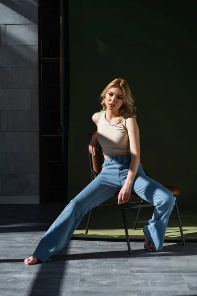 Full Length View Barefoot Woman Jeans Sitting Chair Lighting Dark — Stockfoto