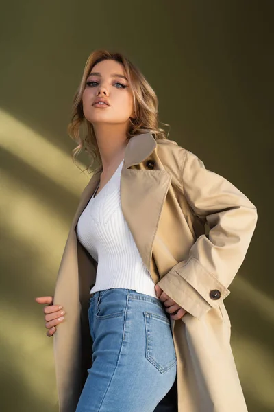 Low Angle View Pretty Woman Trench Coat Jeans Looking Camera — Zdjęcie stockowe