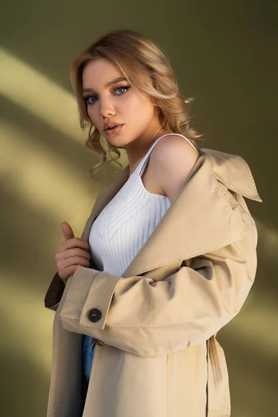 Young Woman Trench Coat White Tank Top Looking Camera Beige — стоковое фото