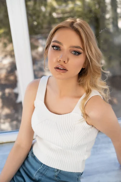 Young Woman White Tank Top Looking Camera Blurred Window — Stockfoto