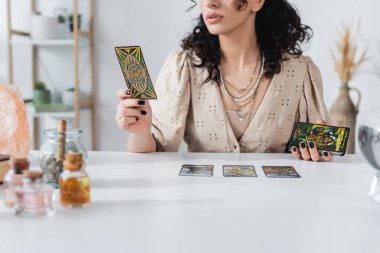 KYIV, UKRAINE - 23 Şubat 2022: Evinde kristalin yanında tarot kartları tutan falcı görüntüsü 