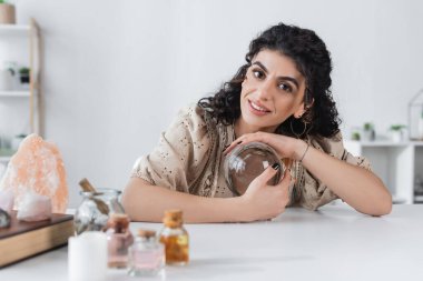 Gülümseyen çingene kahin küreye dokunuyor ve evdeki kameraya bakıyor 