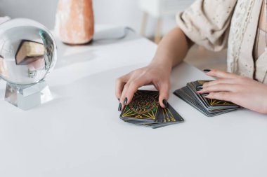 KYIV, UKRAINE - 23 Şubat 2022: Tarot kartlarını masaya yakın tutan falcı görüntüsü