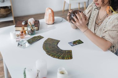 KYIV, UKRAINE - 23 Şubat 2022: Tarot yakınındaki küreyi ve masanın üzerindeki mumları kırpılmış görünüm 