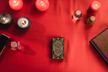 KYIV, UKRAINE - FEBRUARY 23, 2022: Top view of burning candles and tarot cards on table 