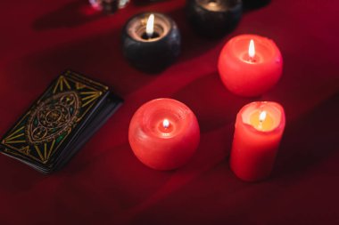 KYIV, UKRAINE - FEBRUARY 23, 2022: High angle view of burning candles near tarot cards on table 