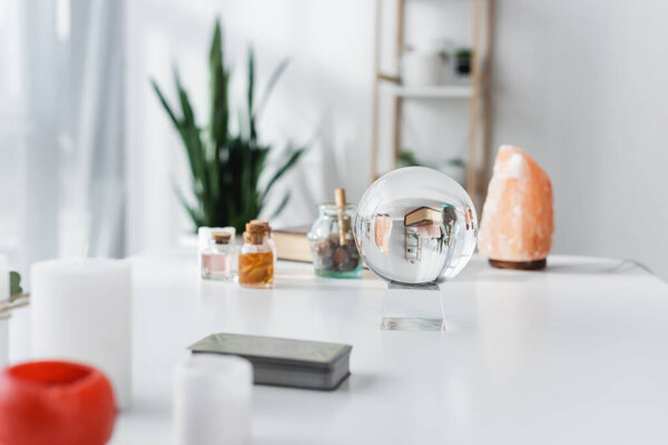 Orb, candles and tarot cards on table 