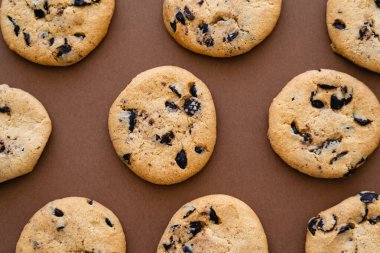 Top view of cookies with chocolate chips on brown background 