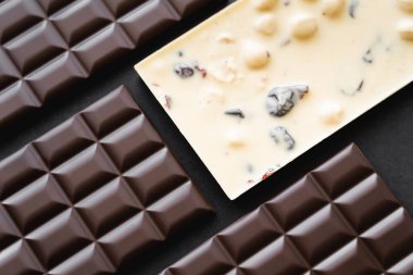 Siyah arkaplanda beyaz ve siyah çikolataların üst görünümü