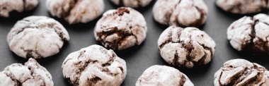 Close up view of biscuits with powdered sugar on black surface, banner 