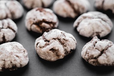 Close up view of cookies with powdered sugar on black background 