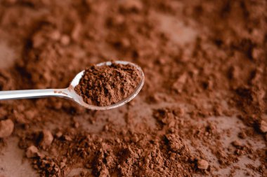 High angle view of cocoa in spoon and on brown background  clipart