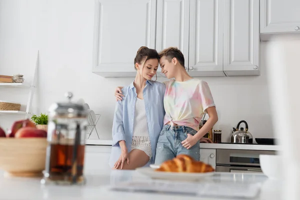Smiling Bigender Couple Embracing Kitchen Blurred Foreground — Φωτογραφία Αρχείου