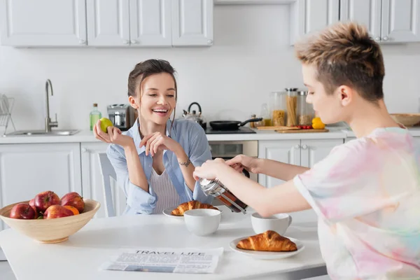 Pansexual Person Pouring Tea Smiling Partner Croissants — Φωτογραφία Αρχείου