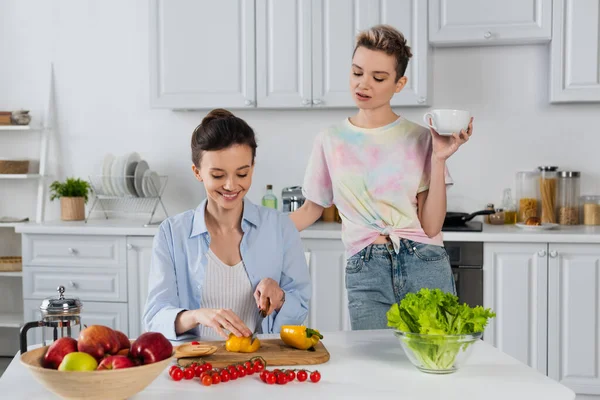 Sonriente Pansexual Persona Cortar Pimiento Cerca Verduras Frescas Pareja Con —  Fotos de Stock