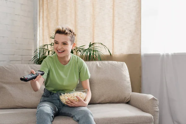 Uśmiechnięty Penseksualista Miską Popcornu Klikając Kanały Telewizyjne Kanapie Domu — Zdjęcie stockowe