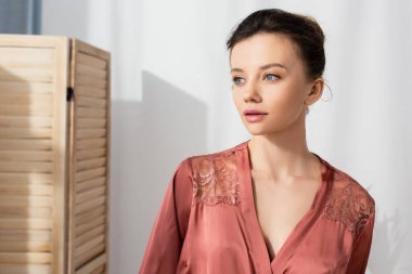 Peignoir 'de güzel esmer bir kadın evine bakıyor.