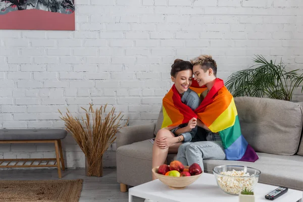 Happy Pangender Couple Sitting Couch Lgbt Flag Apples Popcorn Coffee — Stock Photo, Image