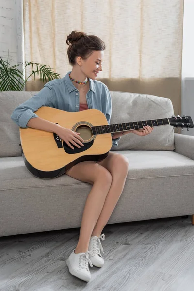 Full Length View Cheerful Woman Sitting Couch Playing Acoustic Guitar — Foto Stock