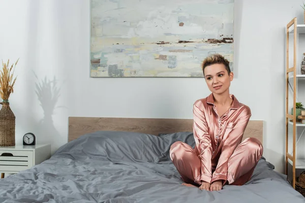 Young Dreamy Pangender Person Silk Pajamas Sitting Bed — Φωτογραφία Αρχείου