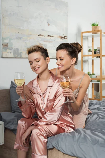 Happy Bigender Lovers Sleepwear Holding Glasses White Wine Bedroom — стоковое фото