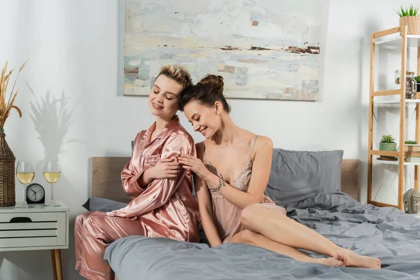 Young Pansexual Partners Sleepwear Smiling Glasses White Wine Bedroom — Foto de Stock