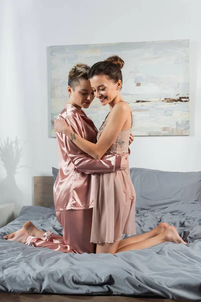 Young Happy Pangender Couple Sleepwear Embracing Bed Home — Fotografia de Stock